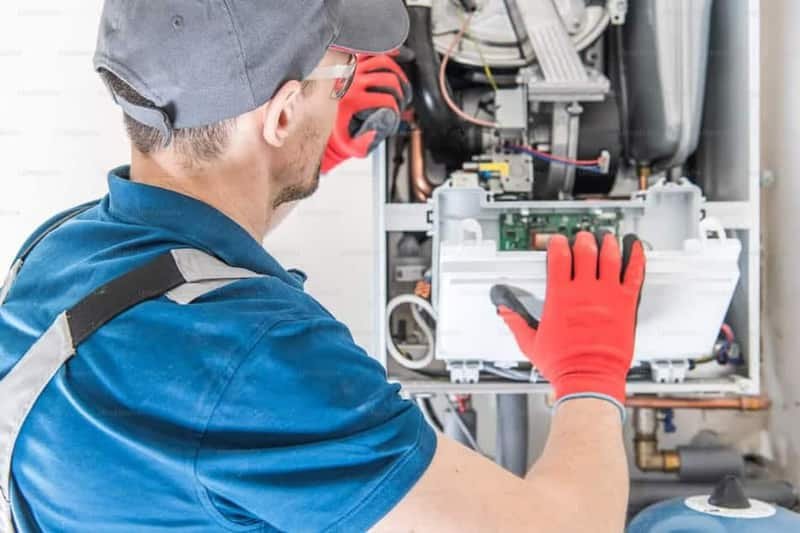 HVAC technician servicing a residential gas furnace in Meridian, Idaho